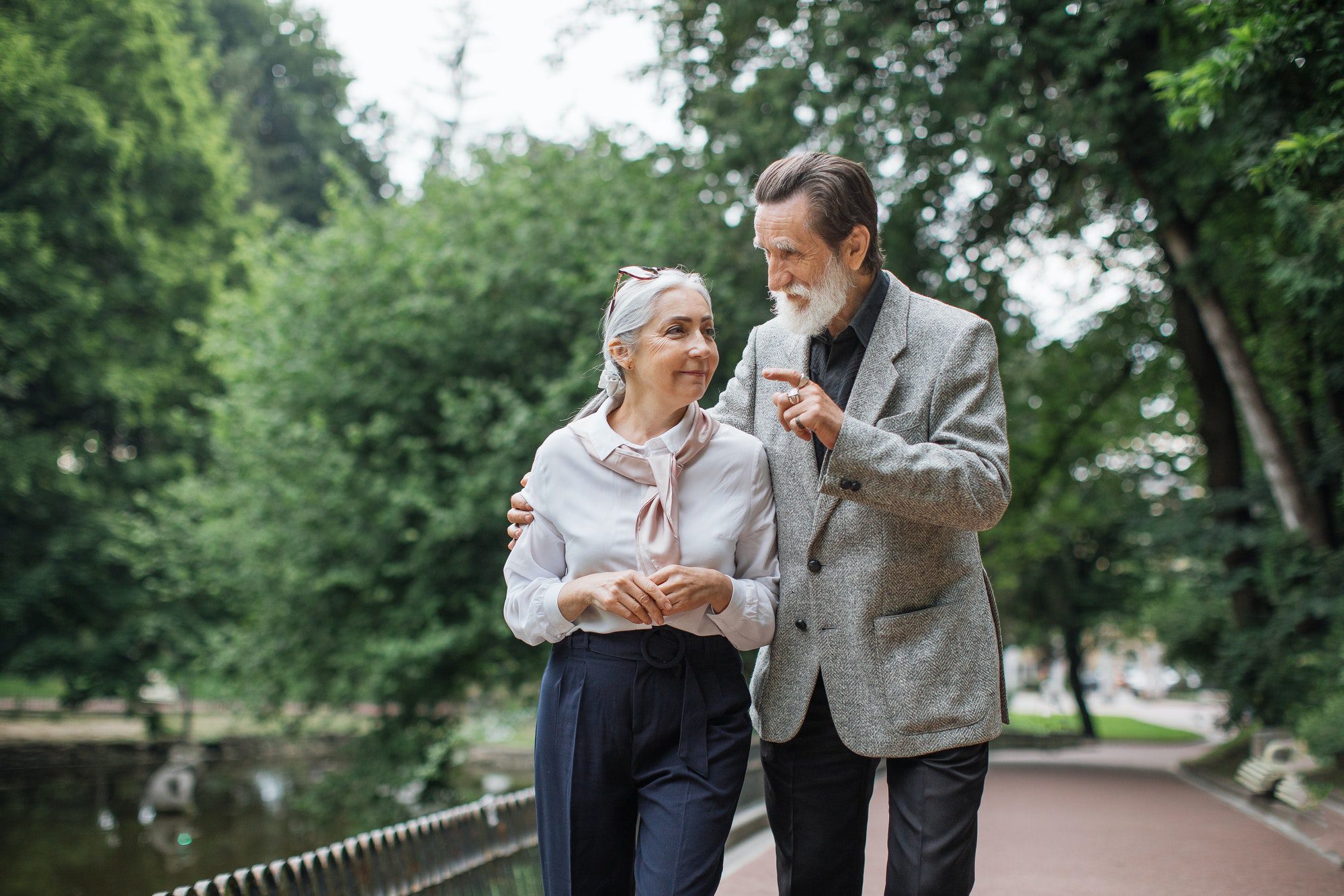 Happy senior couple walking in the park in Missouri while they discuss Medicare in the state.