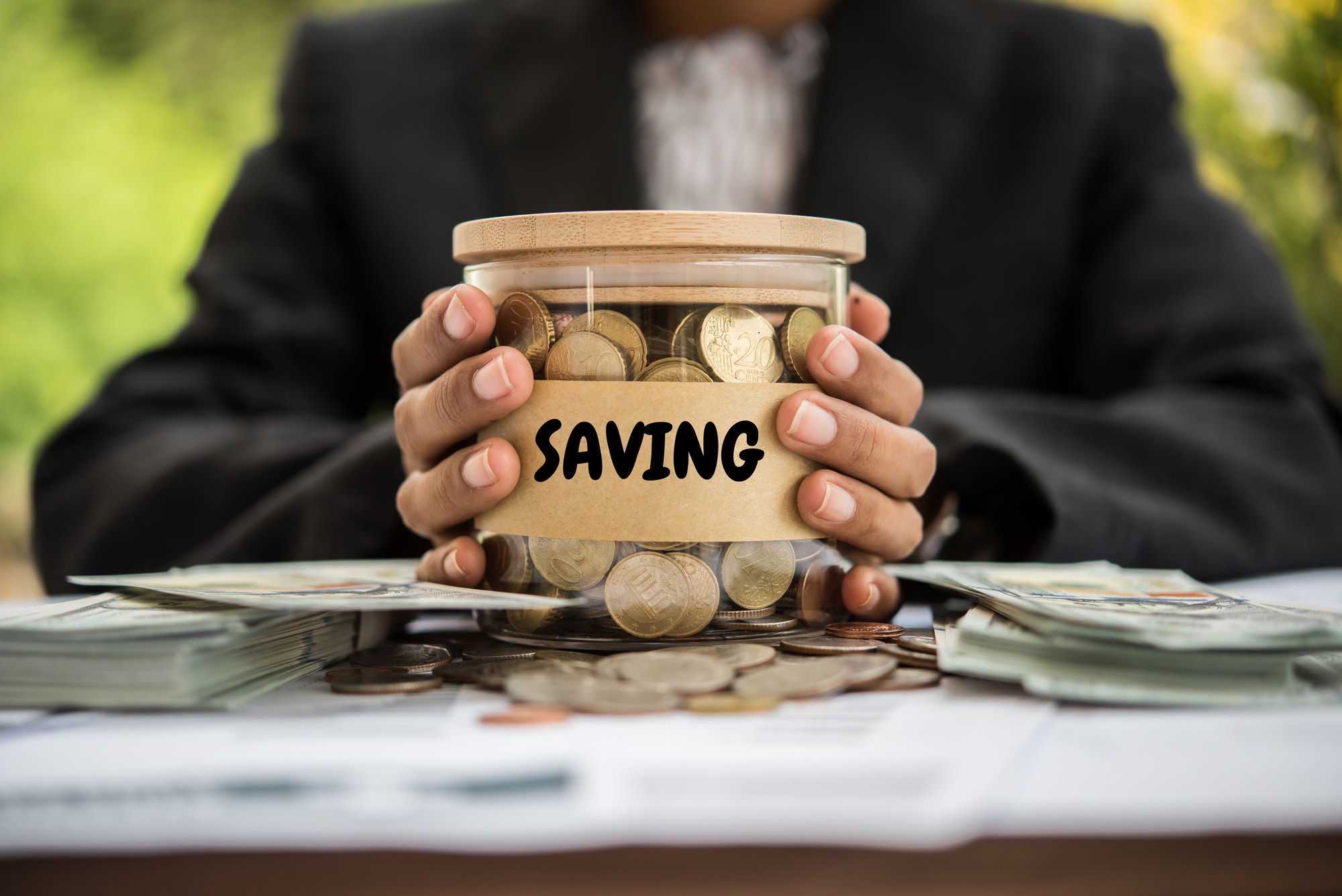Money in a jar labeled savings representing Medicare savings programs.